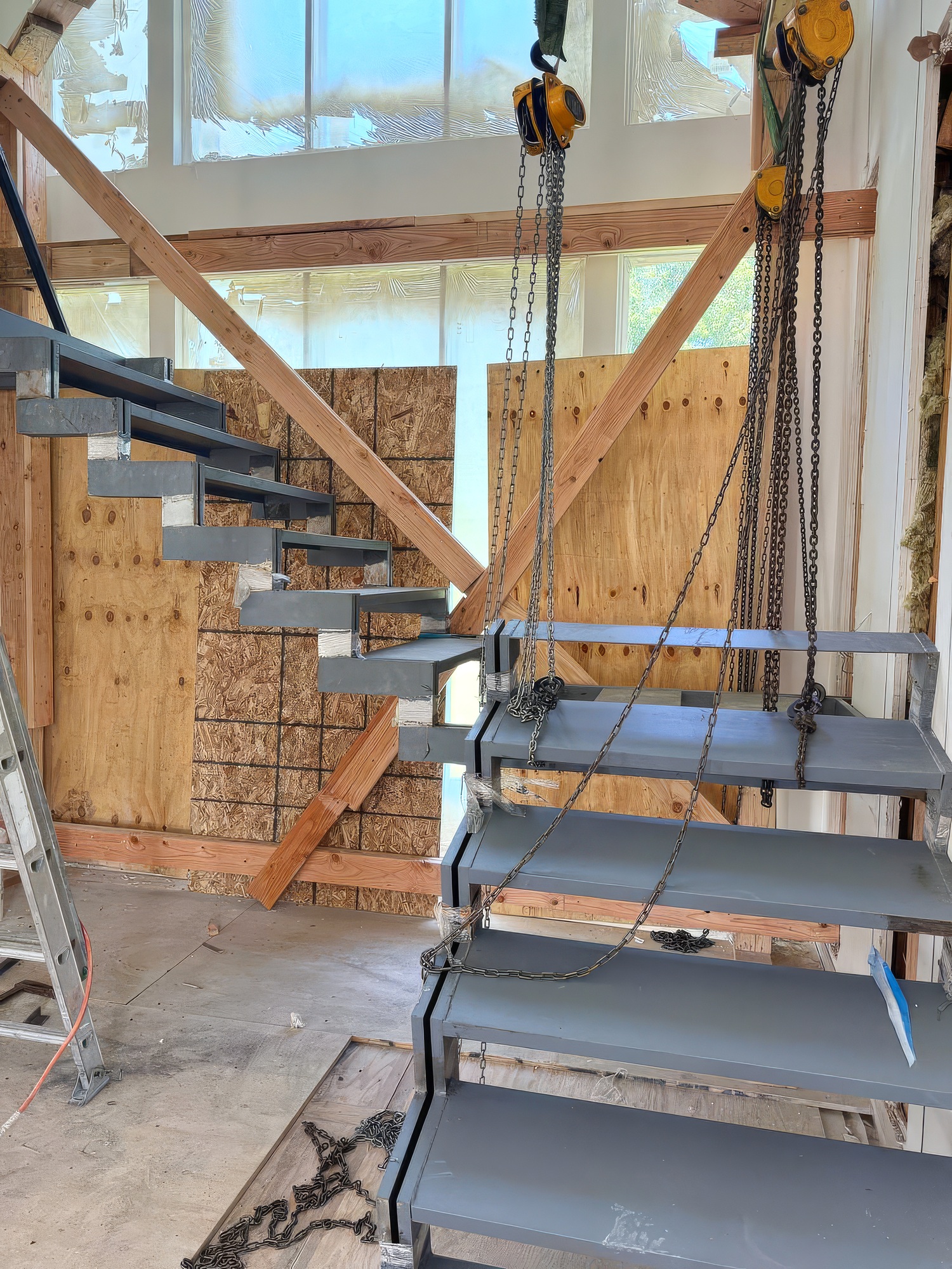 An installation of metal support stairs to second floor is underway in a new building