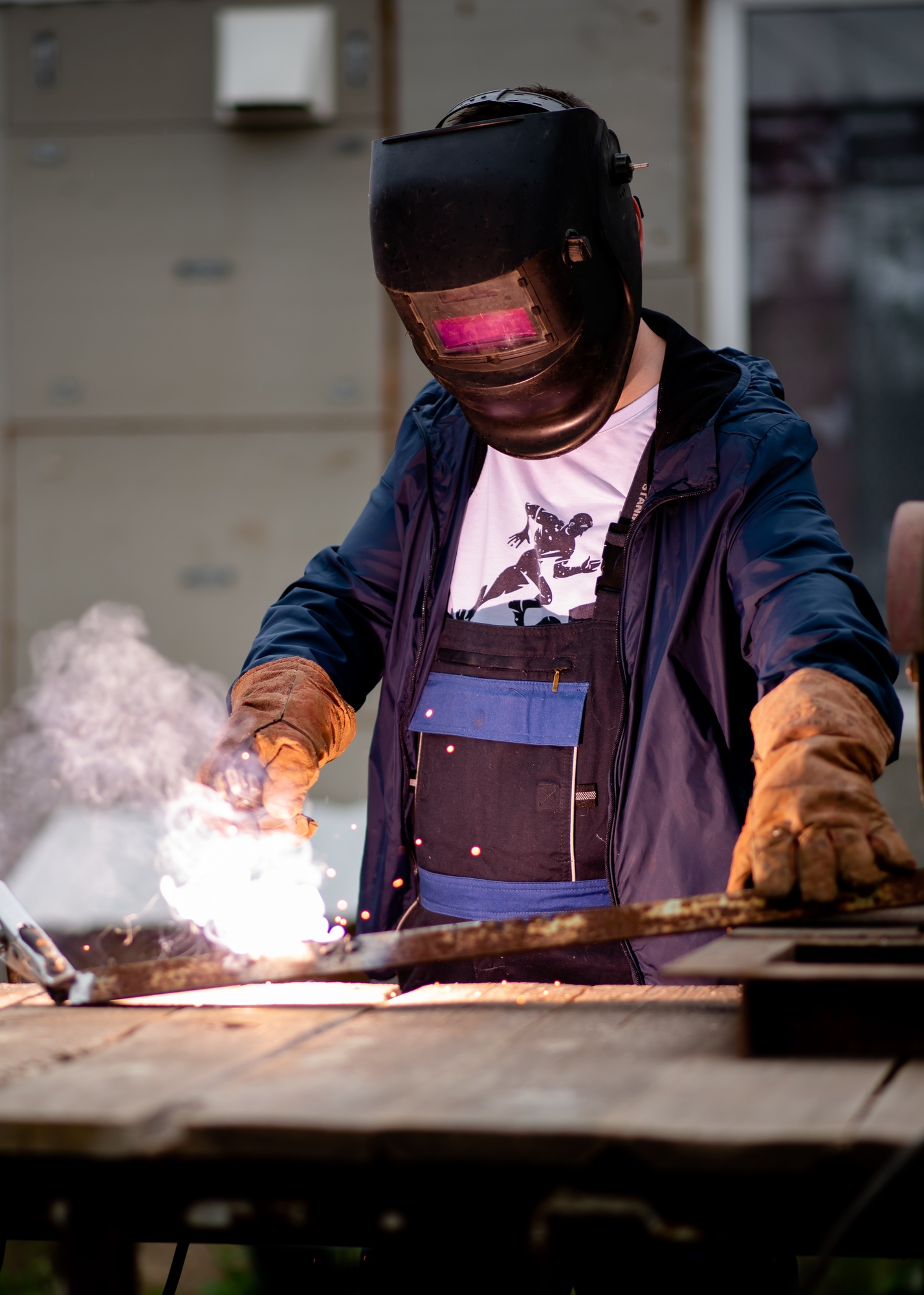The man works with a welding machine.